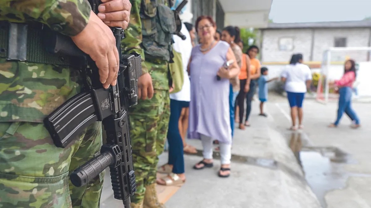 Foto: Especial | PARTICIPACIÓN. Soldados hacían guardia ayer mientras la gente se formaba para votar, durante una consulta popular sobre medidas más duras contra el crimen organizado, en la provincia de Santa Elena.