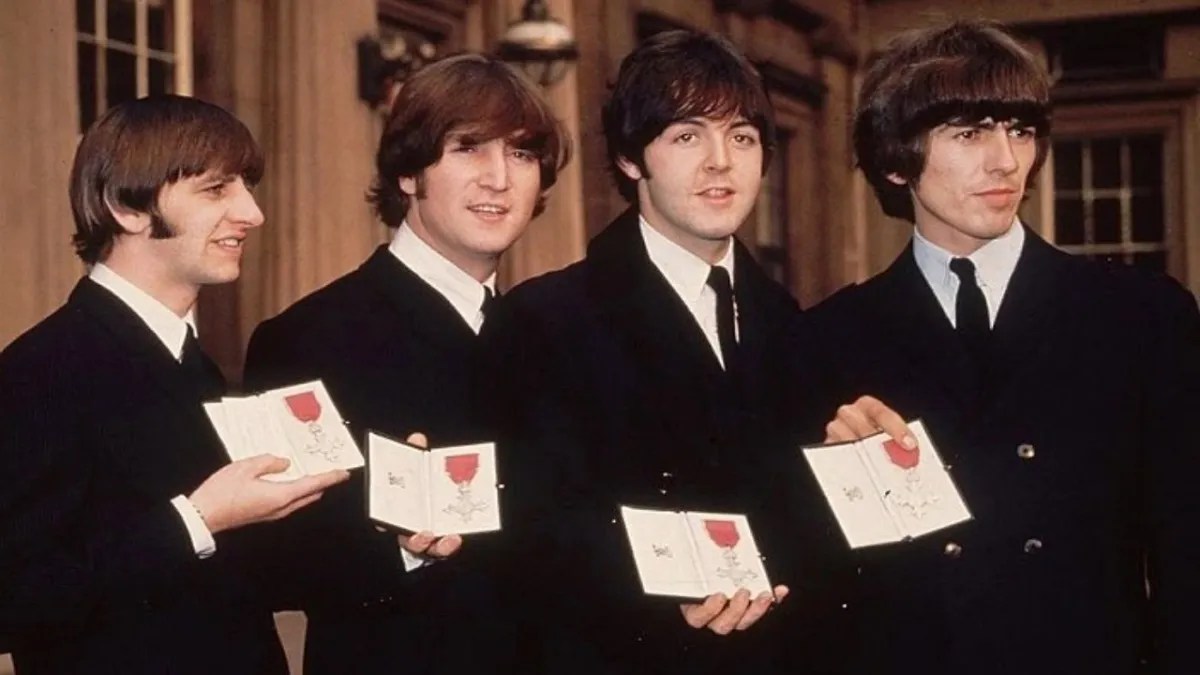 Foto: Paul McCartney. Ringo, John, Paul y George sosteniendo una distinción.